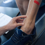 Tendinite releveur du pied : kiné palpe le cou-de-pied, douleur au tibial antérieur